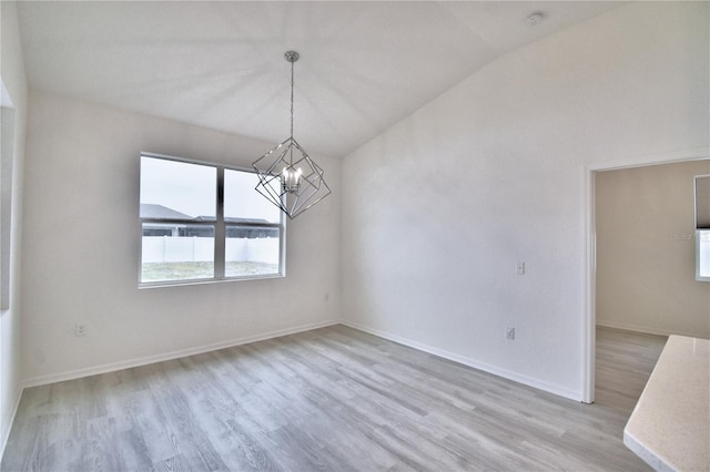 unfurnished dining area featuring lofted ceiling, light hardwood / wood-style floors, and a notable chandelier