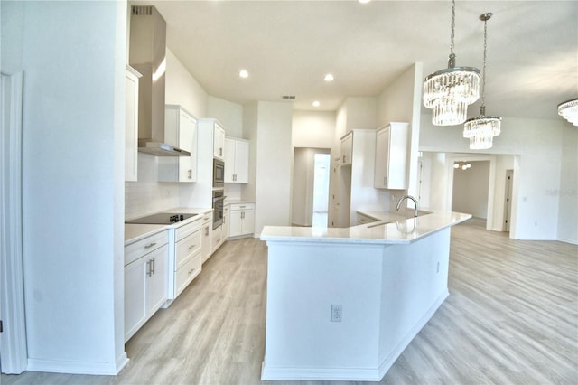 kitchen with white cabinetry, pendant lighting, wall chimney exhaust hood, and appliances with stainless steel finishes