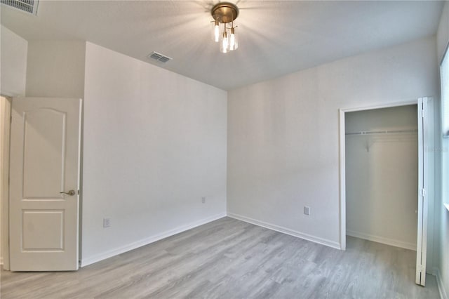 unfurnished bedroom featuring light wood-type flooring and a closet