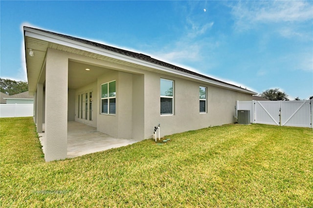 back of property featuring cooling unit, a lawn, and a patio