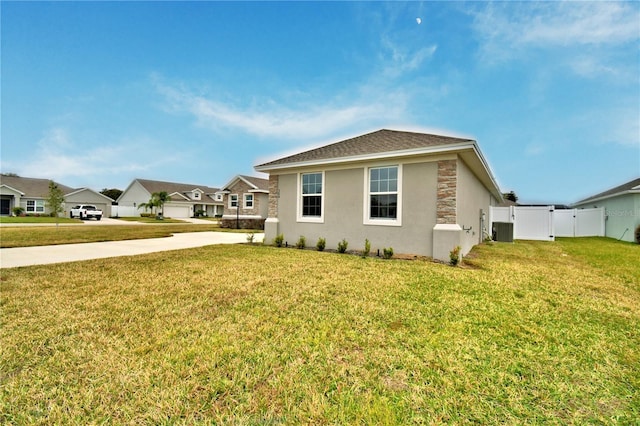 view of home's exterior with a yard and central AC