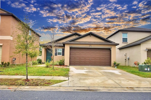 view of front of property with a garage and a lawn