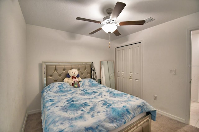 carpeted bedroom featuring ceiling fan and a closet