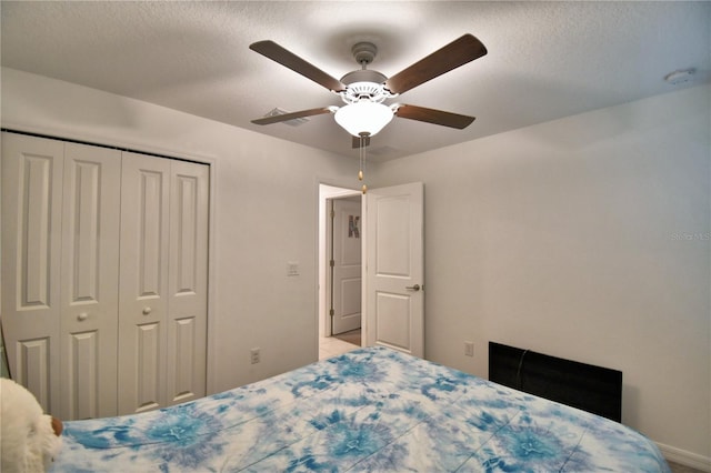 bedroom with a textured ceiling, ceiling fan, and a closet