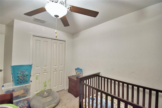 carpeted bedroom featuring a closet and ceiling fan