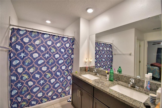 bathroom with vanity, tile patterned floors, and a textured ceiling