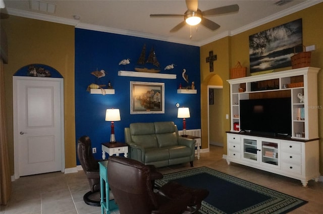 tiled living room with ceiling fan, baseboards, arched walkways, and ornamental molding