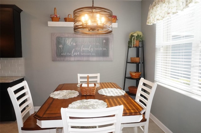 dining area featuring baseboards and a notable chandelier