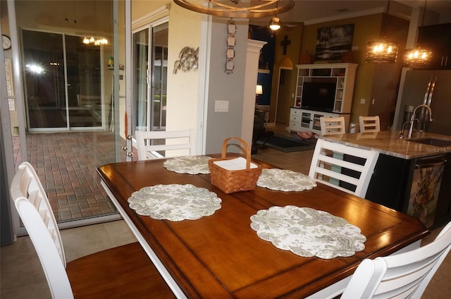 tiled dining space with crown molding and a sink