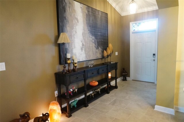 foyer entrance with baseboards and ornamental molding