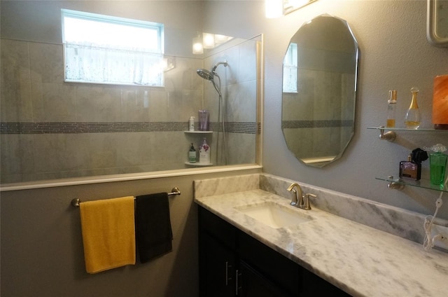 bathroom featuring walk in shower and vanity