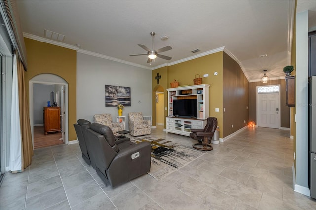 living area featuring arched walkways, ornamental molding, visible vents, and a ceiling fan