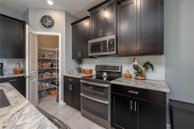 kitchen with decorative backsplash, stainless steel appliances, and light stone counters