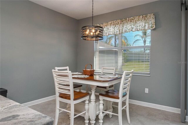 dining area with baseboards, a notable chandelier, and tile patterned flooring