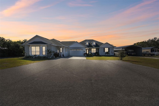 single story home featuring a garage and a lawn