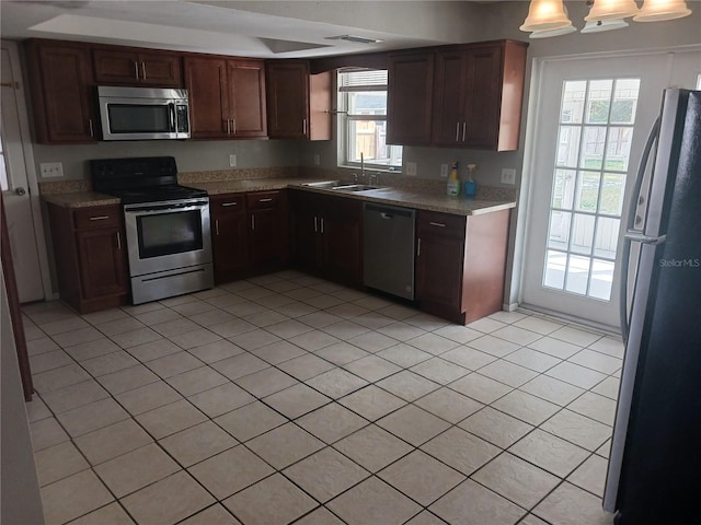 kitchen with stainless steel appliances, sink, and light tile patterned floors