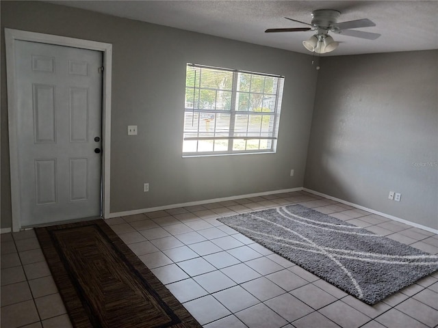 tiled foyer entrance featuring a textured ceiling and ceiling fan