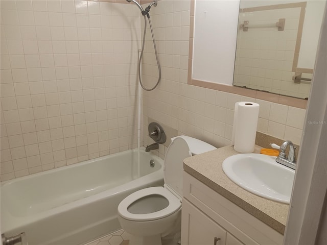 full bathroom featuring tiled shower / bath combo, vanity, tile walls, and toilet