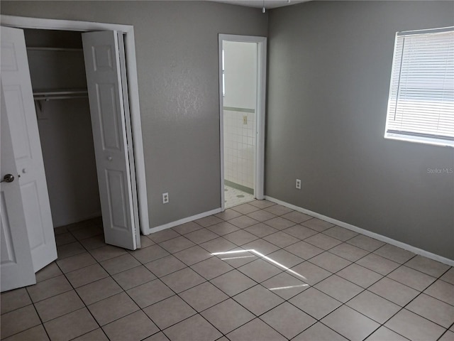 unfurnished bedroom with light tile patterned floors and a closet