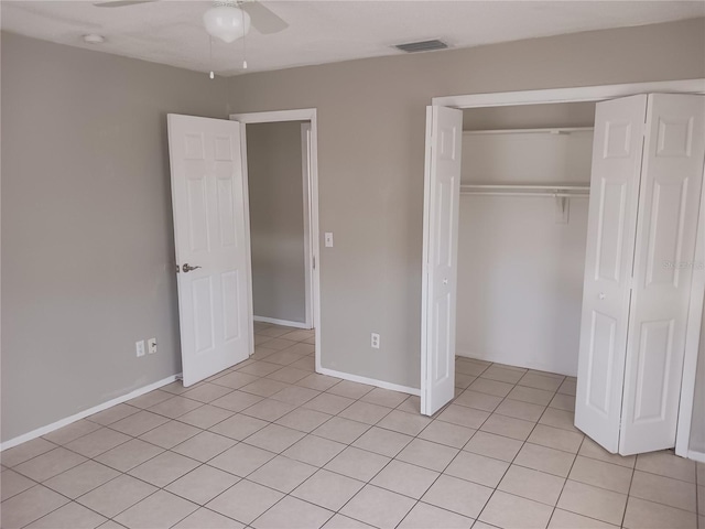 unfurnished bedroom with light tile patterned floors, ceiling fan, and a closet