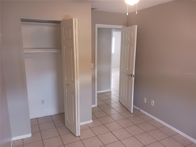 unfurnished bedroom featuring light tile patterned floors and a closet