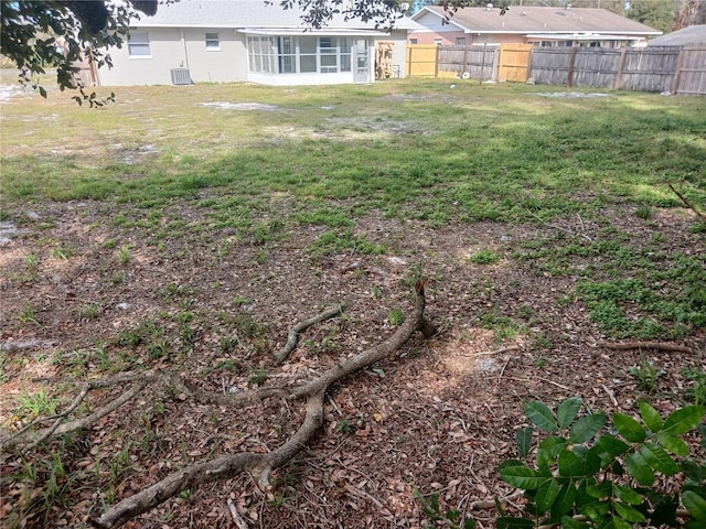 view of yard with a sunroom and central air condition unit