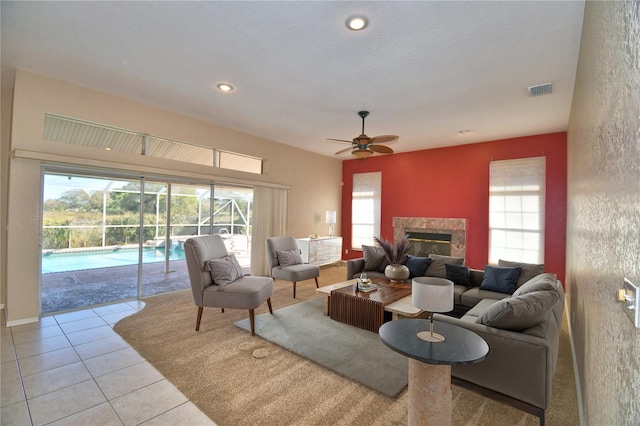 tiled living room featuring ceiling fan and a premium fireplace