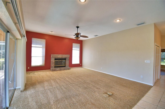 unfurnished living room featuring a premium fireplace, light carpet, and a wealth of natural light