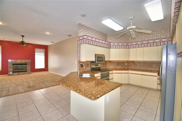 kitchen featuring ceiling fan, stainless steel appliances, kitchen peninsula, and sink