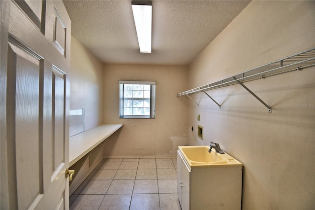 washroom featuring light tile patterned flooring, electric dryer hookup, sink, and a textured ceiling