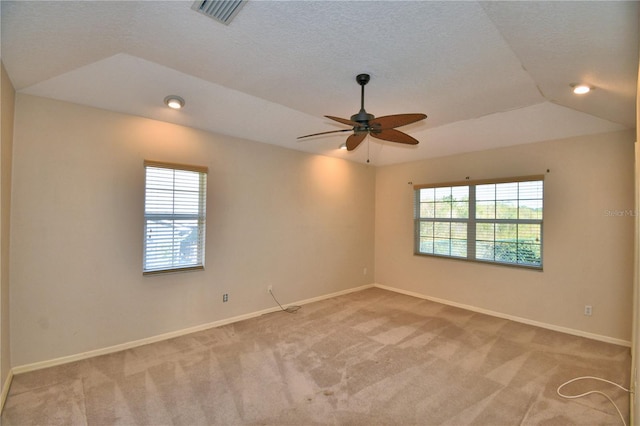 carpeted spare room with lofted ceiling, ceiling fan, and a textured ceiling