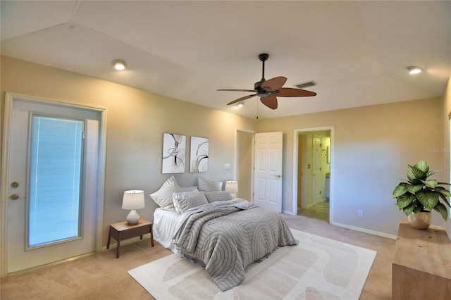 bedroom featuring ceiling fan, light colored carpet, and ensuite bath