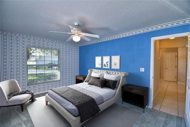 bedroom featuring light tile patterned flooring, ceiling fan, and a textured ceiling