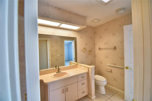 bathroom featuring vanity, a skylight, tile patterned floors, and toilet