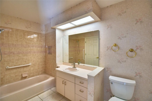 full bathroom featuring tiled shower / bath, a skylight, vanity, toilet, and tile patterned floors