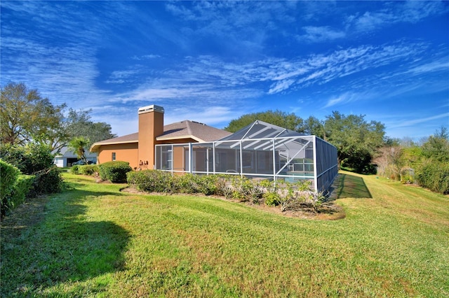 back of house featuring a yard and a lanai