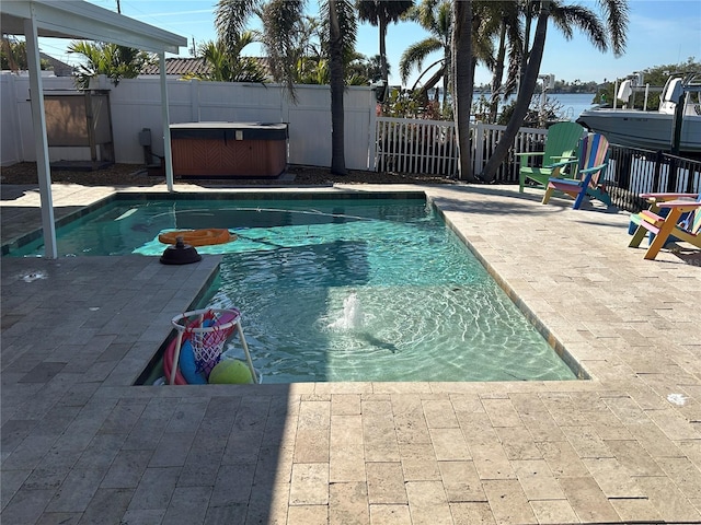 view of pool with a water view, a hot tub, and a patio