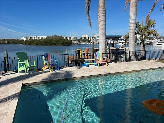 view of swimming pool featuring a patio and a water view