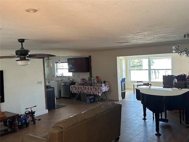 living room with ceiling fan, sink, and a textured ceiling