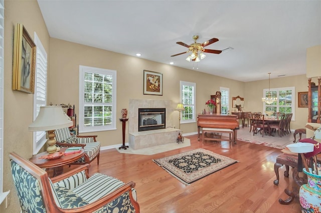 living room featuring hardwood / wood-style flooring, a premium fireplace, and ceiling fan