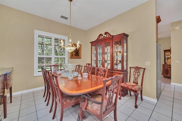 tiled dining space featuring an inviting chandelier