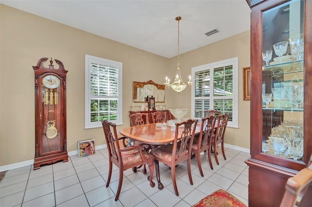 tiled dining room featuring plenty of natural light and a chandelier