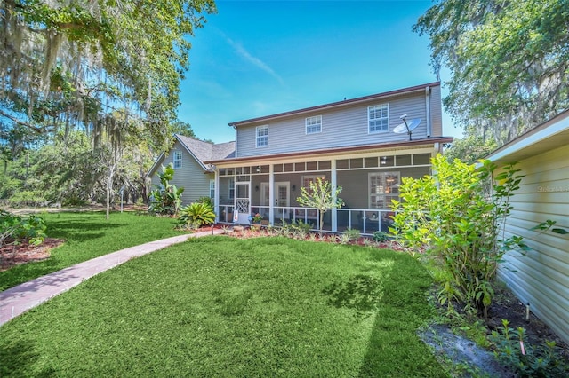 back of house with a yard and a sunroom