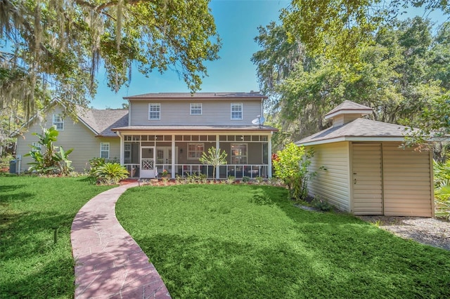 rear view of property featuring a yard and a sunroom