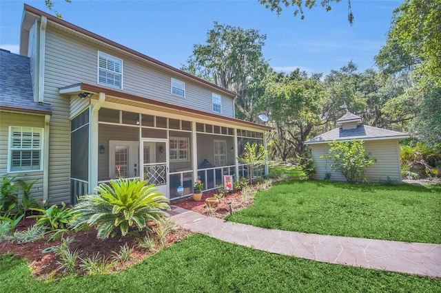 back of house with a yard and a sunroom