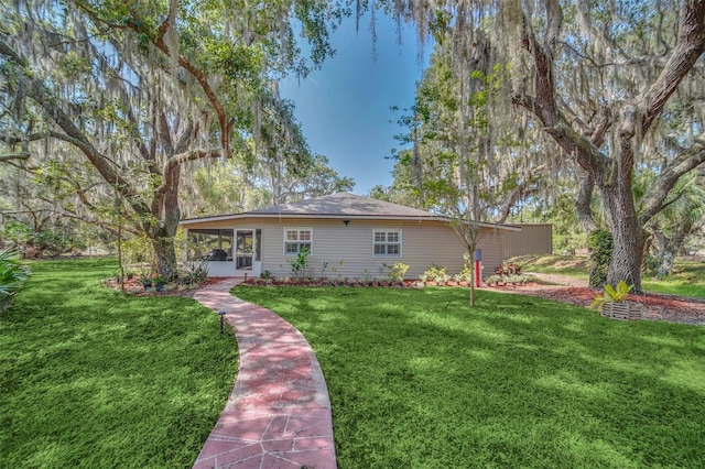 view of front of home with a sunroom and a front yard