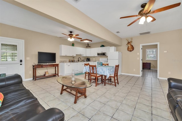 tiled living room featuring ceiling fan and sink