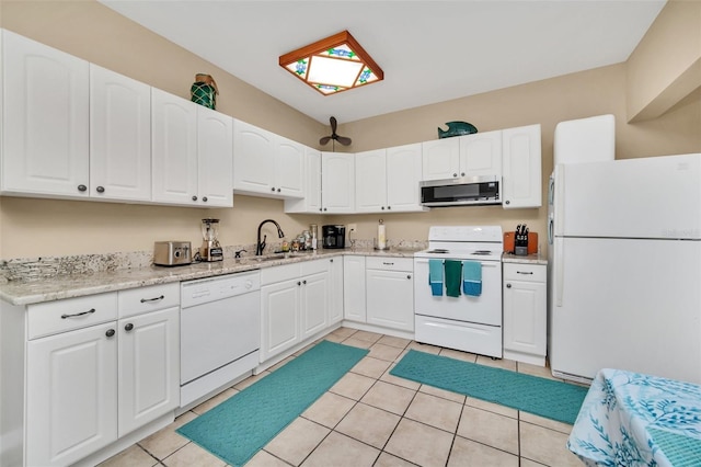 kitchen with sink, light tile patterned floors, white cabinets, and white appliances