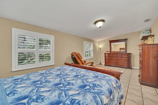 tiled bedroom featuring multiple windows and lofted ceiling