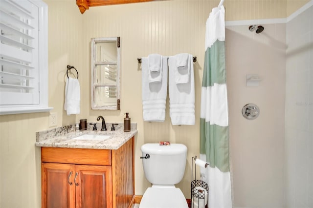 bathroom featuring vanity, toilet, and walk in shower